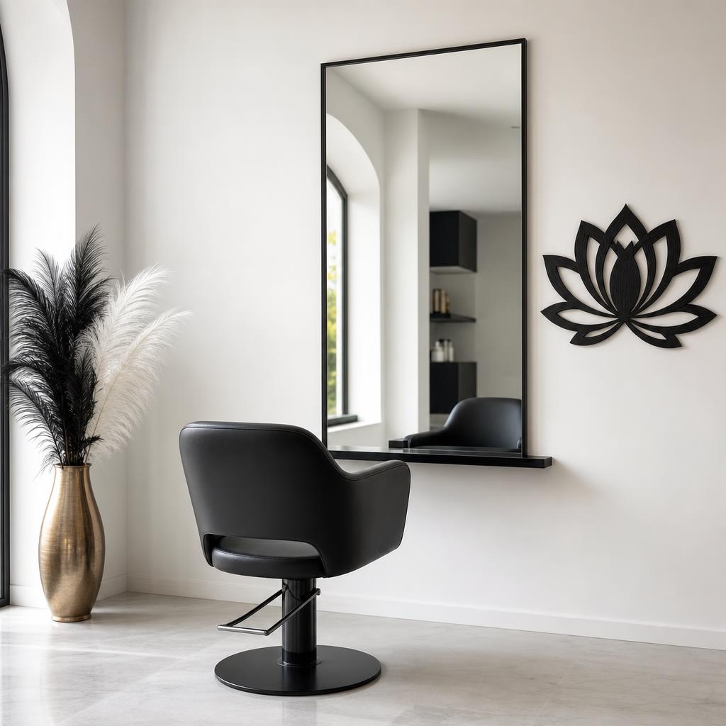 Minimalist solo beauty salon interior with a single black styling chair, black-and-white feather accents, and one black wooden lotus flower on the wall